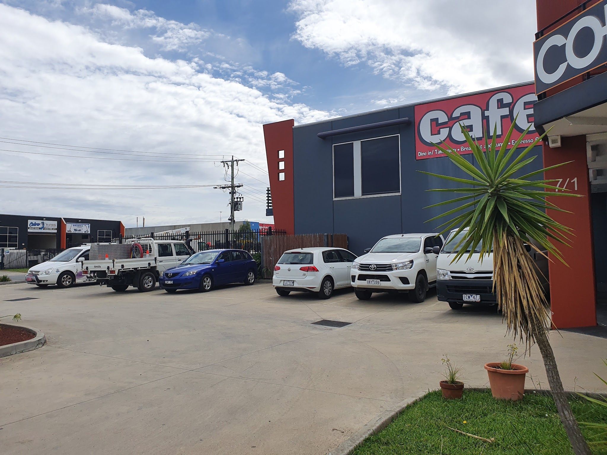 Cafe building exterior in an industrial estate with cars parked outside