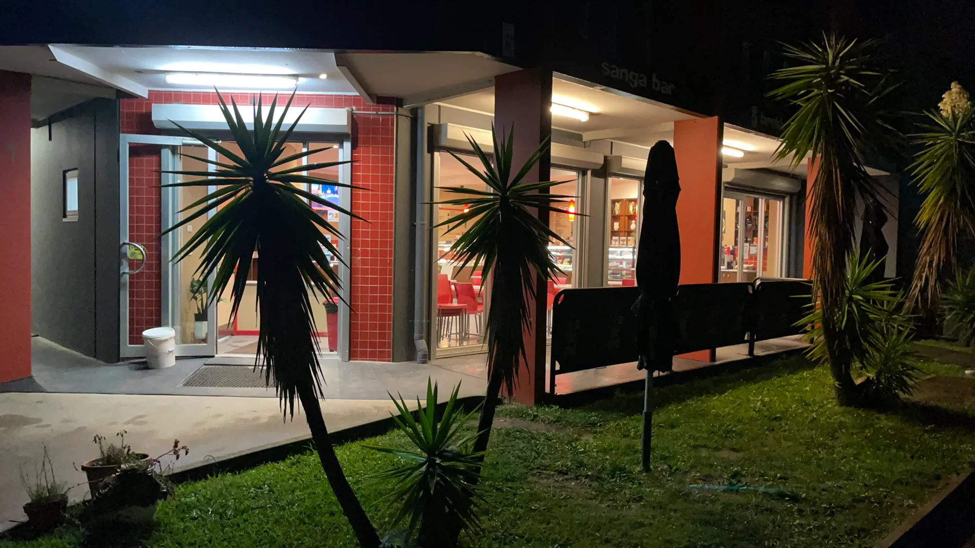 Coffee On Bate shopfront and outdoor seating lit at night