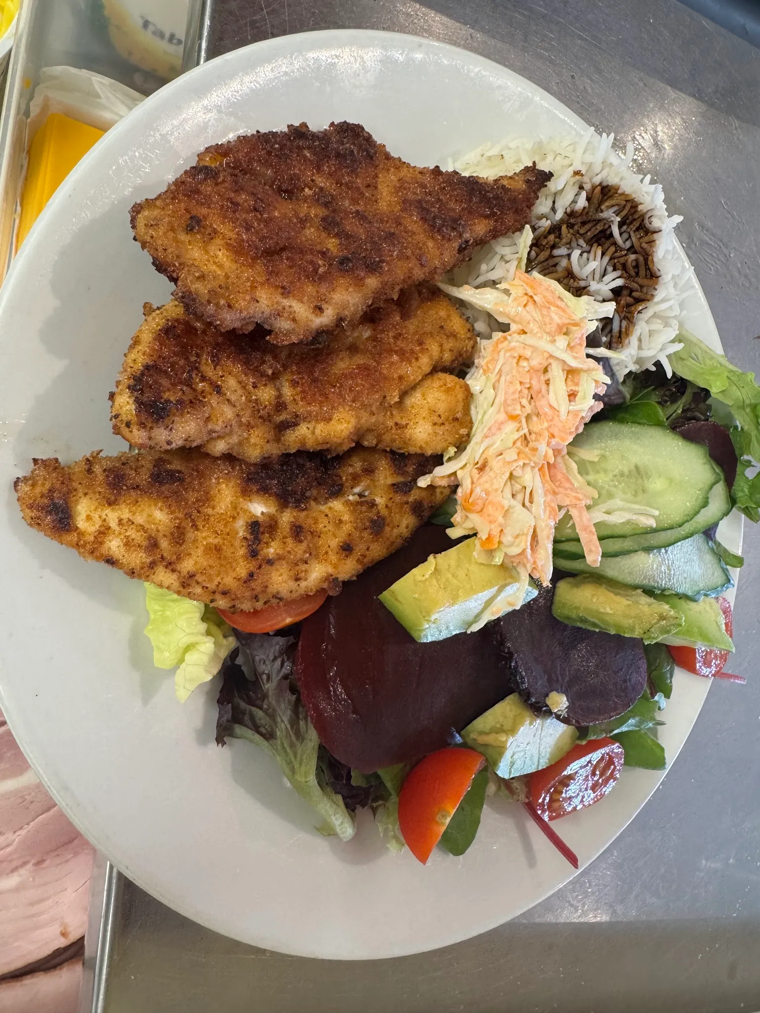Crumbed chicken schnitzels with rice, coleslaw and salad