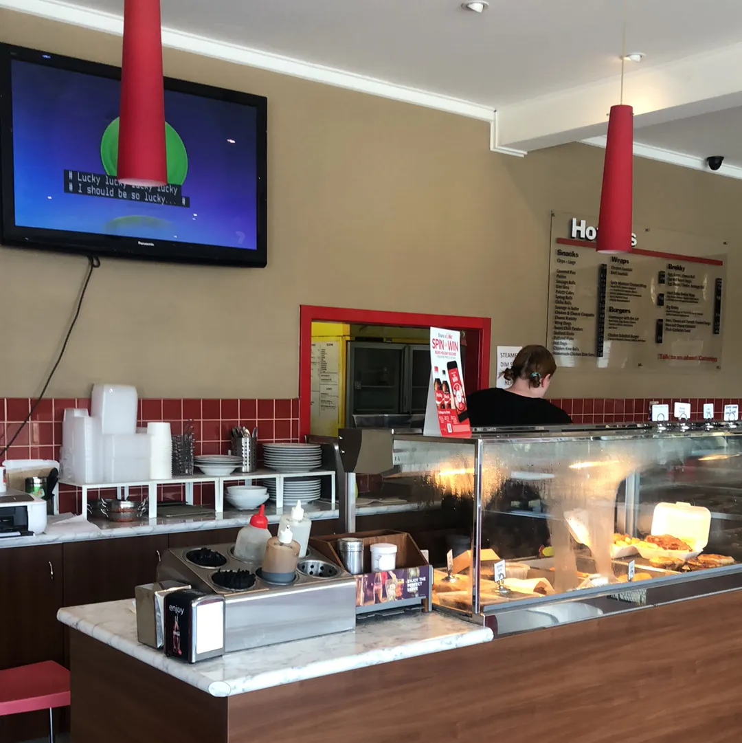 Staff member serving at the hot food counter inside the cafe