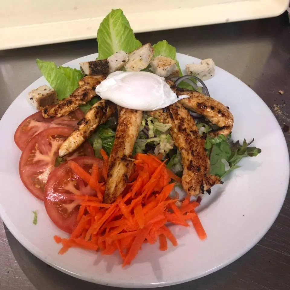 Chicken Caesar salad with poached egg, croutons and tomato